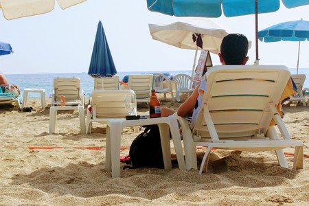 July, 2017 - A man is resting with a bottle of beer lying on a sunbed on Cleopatra Beach (Alanya, Turkey).のeditorial素材