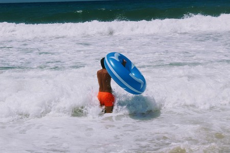July, 2017 - A tanned man with a large inflatable blue circle for swimming in the sea (Alanya, Turkey).のeditorial素材