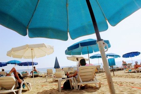 July, 2017 - A man is resting with a bottle of beer lying on a sunbed on Cleopatra Beach (Alanya, Turkey).のeditorial素材