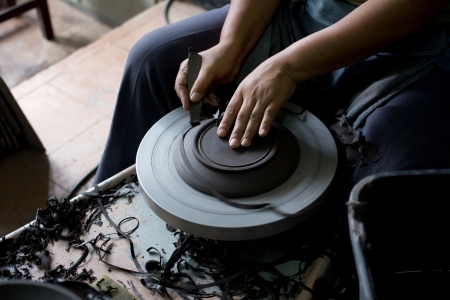 Potter shaping clay bowl on wheelの写真素材