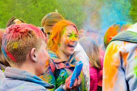 Moscow, Russia - June 3, 2017: Happy laughing red-haired girl in the epicenter of a colorful splash at the Holi festival. Traditional Indian festival turned into a fun event in many countriesのeditorial素材