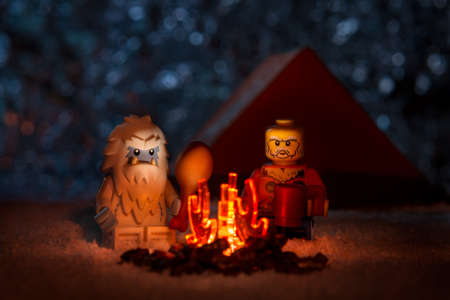 Moscow, Russia - May 5, 2019: Lego-man with Yeti near bonfire on starry sky background, funny concept unreal friendshipのeditorial素材