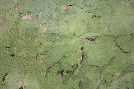 Dirty texture of plaster and green paint, shabby aged surface, remnants of peeling cracked stucco, grunge uneven wallの写真素材