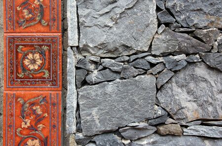 a part of the wall of stone with a border of tiles with a lookの写真素材
