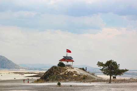 building on a hill with the flag of Turkey and the use of ecological solar energy on the shore of lake Saldaの写真素材