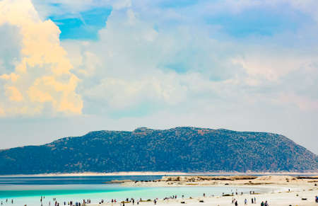 people relax on the white shore of the azure lake Salda against the background of mountains and blue skyの写真素材