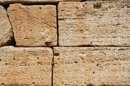 background of large blocks walls of an old building with the texture of stone from age and wind on a...