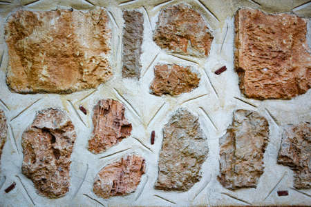 background of the building wall made of stones with white plasterの写真素材