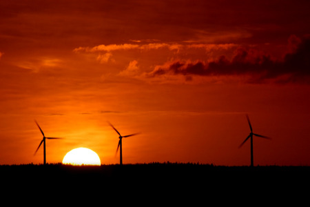 Three windmills with sunset (motion blur)の写真素材
