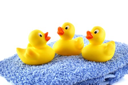 Three rubber ducks on a blue towelの写真素材