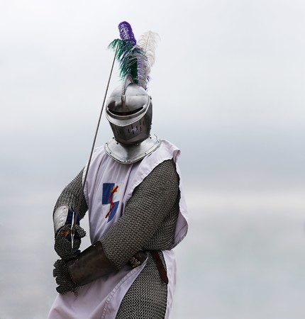 Knight with a sword in mail shirt, armament and helmet (copy space)