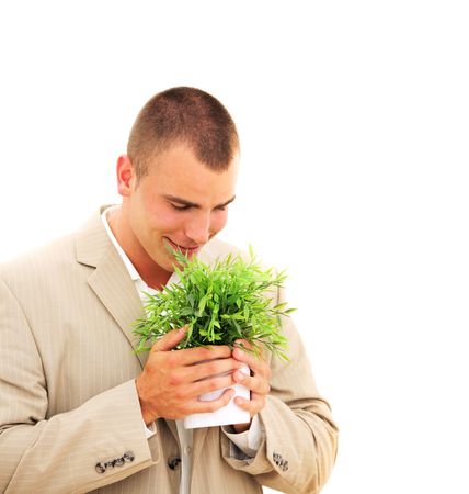 Handsome businessman enjoying his plant isolated on whiteの写真素材