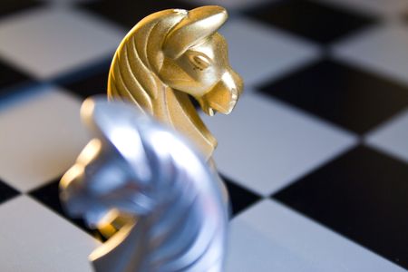 Gold chess horse meet with silver chess horse. Focus on gold chess horse.の写真素材