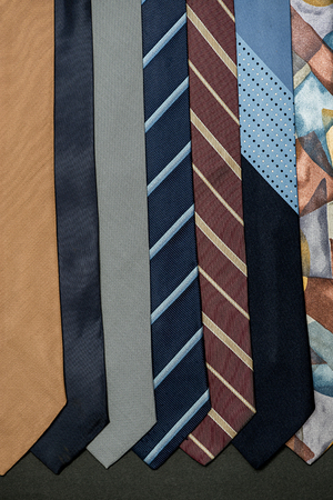 several different colors ties hanging on black backgroundの写真素材