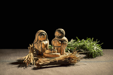 Christmas Crib. Figures of Baby Jesus, Virgin Mary and St. Joseph over a black backgroundの写真素材