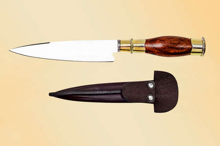 handmade knife with leather scabbard on yellow backgroundの写真素材