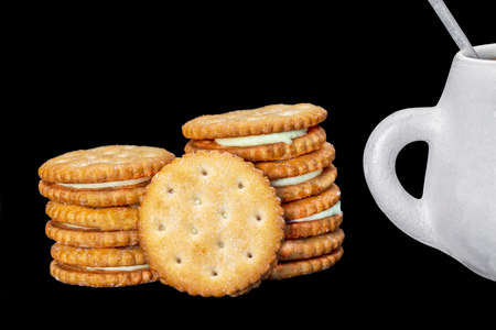 lemon filled biscuits with a rustic ceramic cup on a black backgroundの写真素材