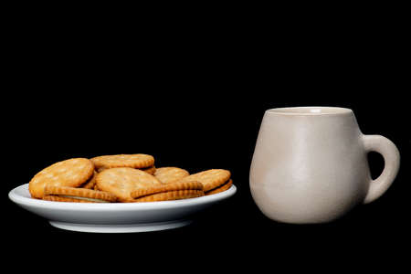 white plate with lemon cookies with cup of coffee on black backgroundの写真素材