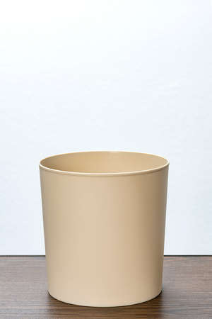 beige plastic trash bin on white backgroundの写真素材