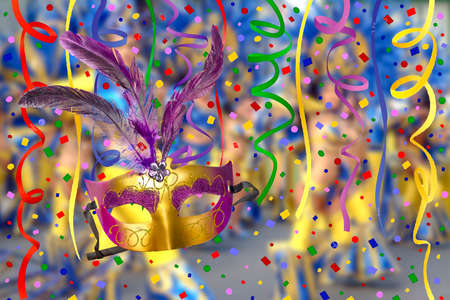 carnival bugle and blue carnival mask over confetti and multi-colored streamers on black backgroundの写真素材