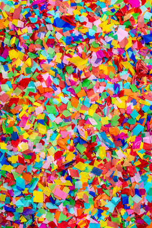 carnival bugle and blue carnival mask over confetti and multi-colored streamers on black backgroundの写真素材
