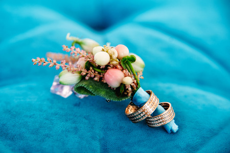 boutonniere with two wedding rings on blue backgroundの写真素材