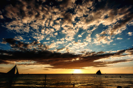 sea sunset with sailboats in tropical country, dramatic clouds. Philippinesの写真素材