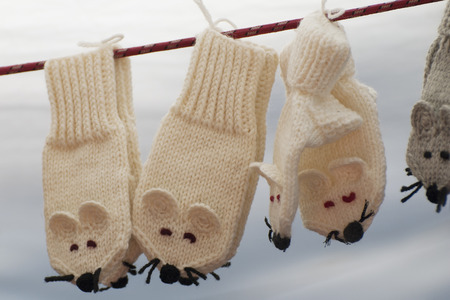 Funny wool mittens hanging on clotheslineの写真素材