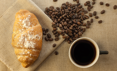 Cup of coffee and croissants on a linen backgroundの写真素材