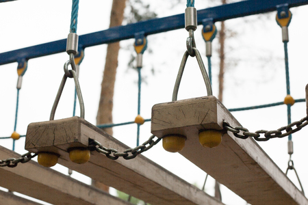 Suspension bridge with wooden steps. Focus on the boards of bridgeの写真素材