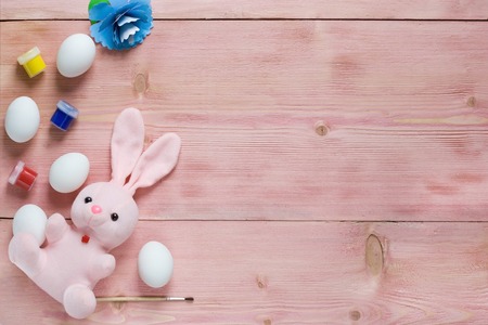 Easter festive set with eggs, flower and easter rabbit, paint, brush on rustic wooden table with copyspace. Flat lay, space for mock up and copy space. Top viewの写真素材