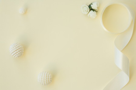 Styled stock photo. Feminine wedding desktop mockup. White roses, satin ribbon, beads on delicate...