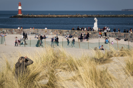 Photographer at the beach on a sunny day Warnemuende Germanyのeditorial素材