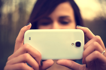 Portrait of beautiful young woman take a photo with mobile phoneの写真素材