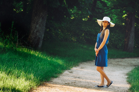 Attractive young adult woman in outdoor blue dressの写真素材