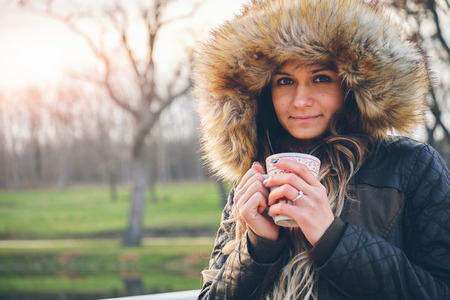 Young woman holding cup her hand