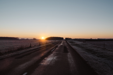 Asphalt road across morning rural countrysideの写真素材