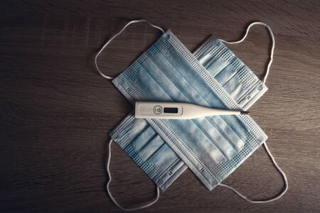 Coronavirus COVID-19 prevention travel surgical masks and electronic modern thermometerの写真素材