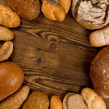 Breads, rolls and buns on wooden background