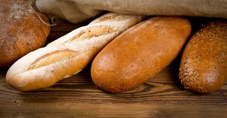 Breads and baguettes on wooden background