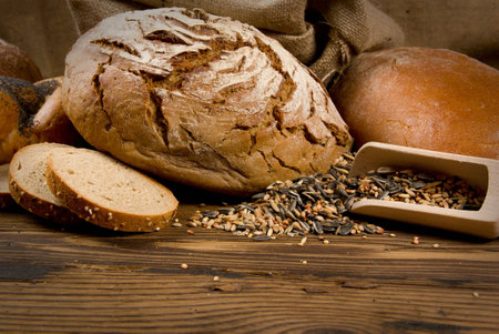 Bread and buns with wooden spoon on wooden backgroundの写真素材