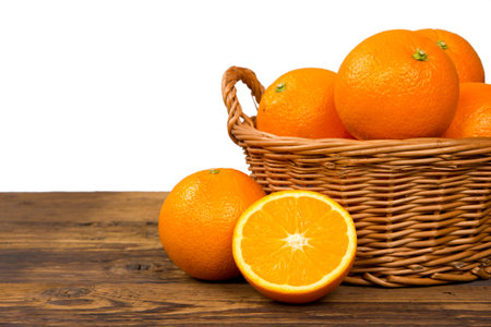 Photo of oranges in a basket on wooden deskの写真素材