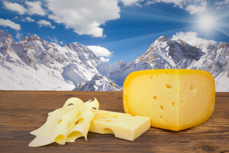 Photo of cheese on wooden board with sky backgroundの写真素材