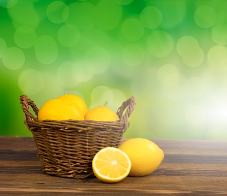 Photo of lemons in a basket with abstract backgroundの写真素材