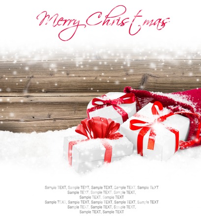 Still life with Christmas bag full of gifts on wooden board covered with snowの写真素材