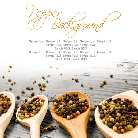 Photo of spoons with pepper seeds on wooden board with white space for textの写真素材