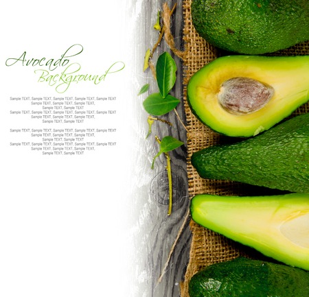Photo of avocados with slice and leaves on burlap and wooden boardの写真素材