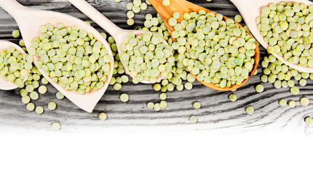Photo of spoons with lentils on wooden board with white space for textの写真素材