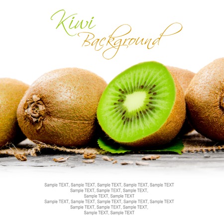 Photo of kiwi with slice on burlap and wooden board with white spaceの写真素材