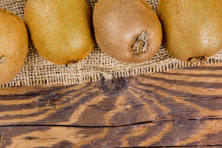 Photo of kiwi on burlap and wooden boardの写真素材